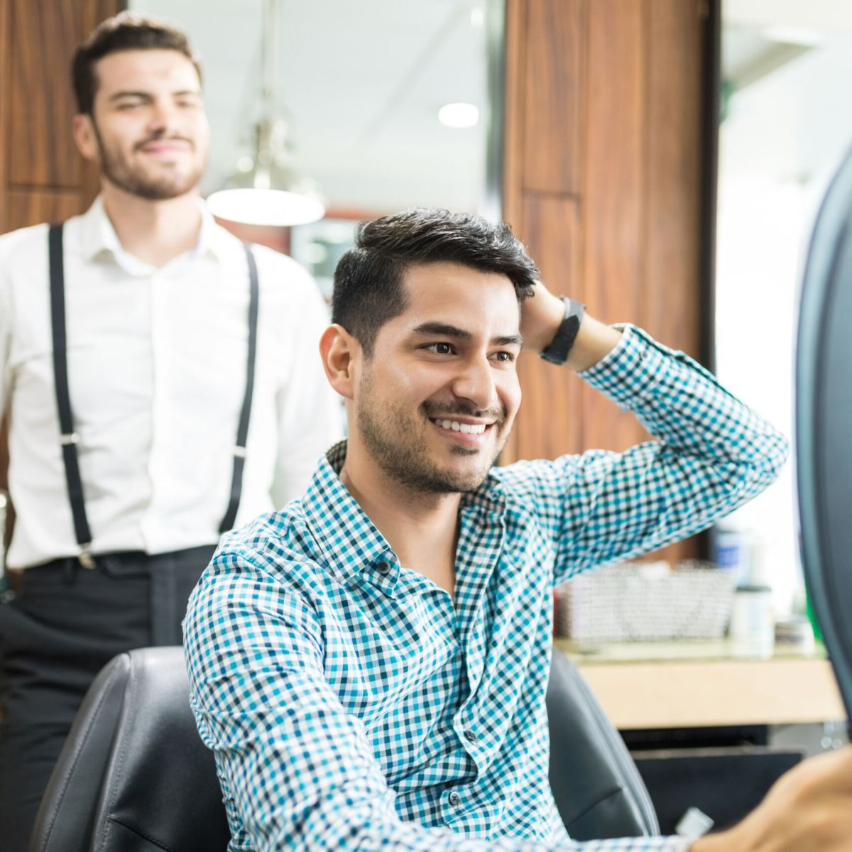 Man smiling while holding a mirror.